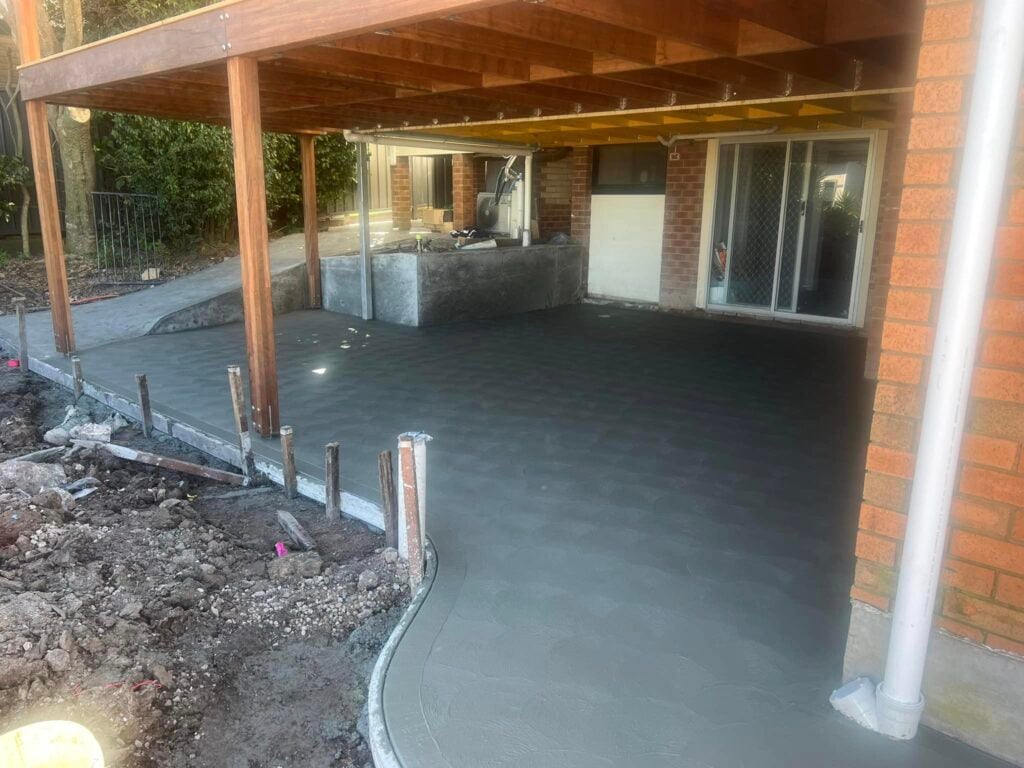 Freshly poured concrete patio beneath timber deck