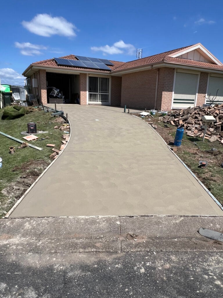 Newly poured concrete driveway at brick suburban home