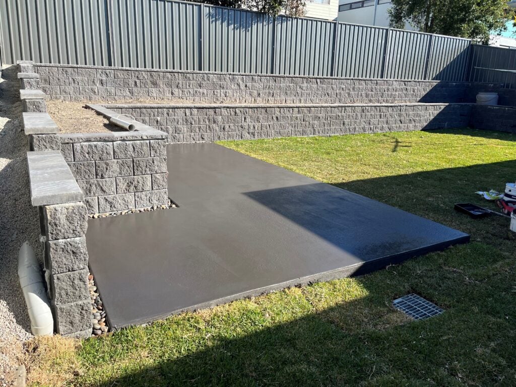 New concrete slab beside tiered retaining walls