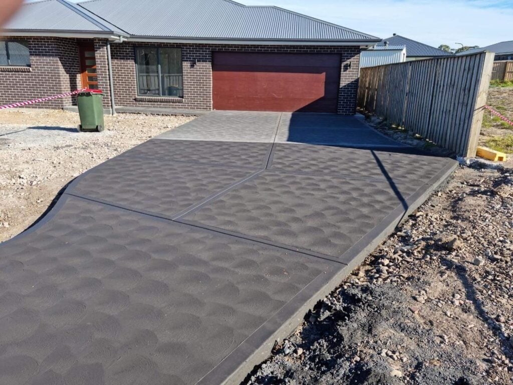 New decorative concrete driveway in front of brick home