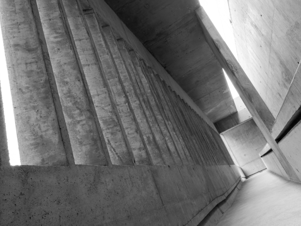 Black-and-white concrete architectural corridor with tall columns