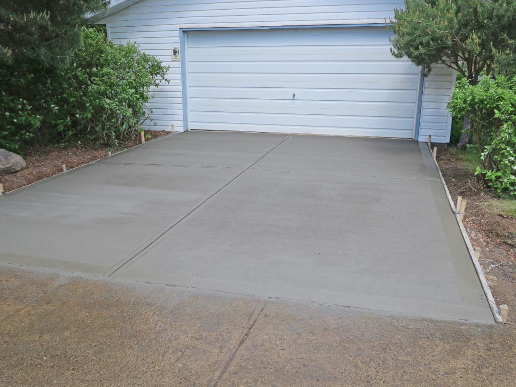 Freshly poured concrete driveway in front of garage