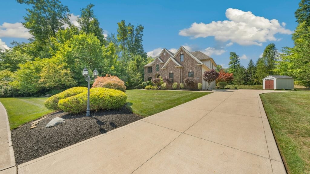 Large brick home with landscaped garden and driveway