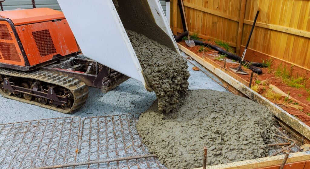 Mini dumper pouring concrete onto reinforced slab base
