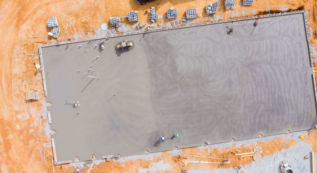 Aerial view of workers smoothing large concrete slab