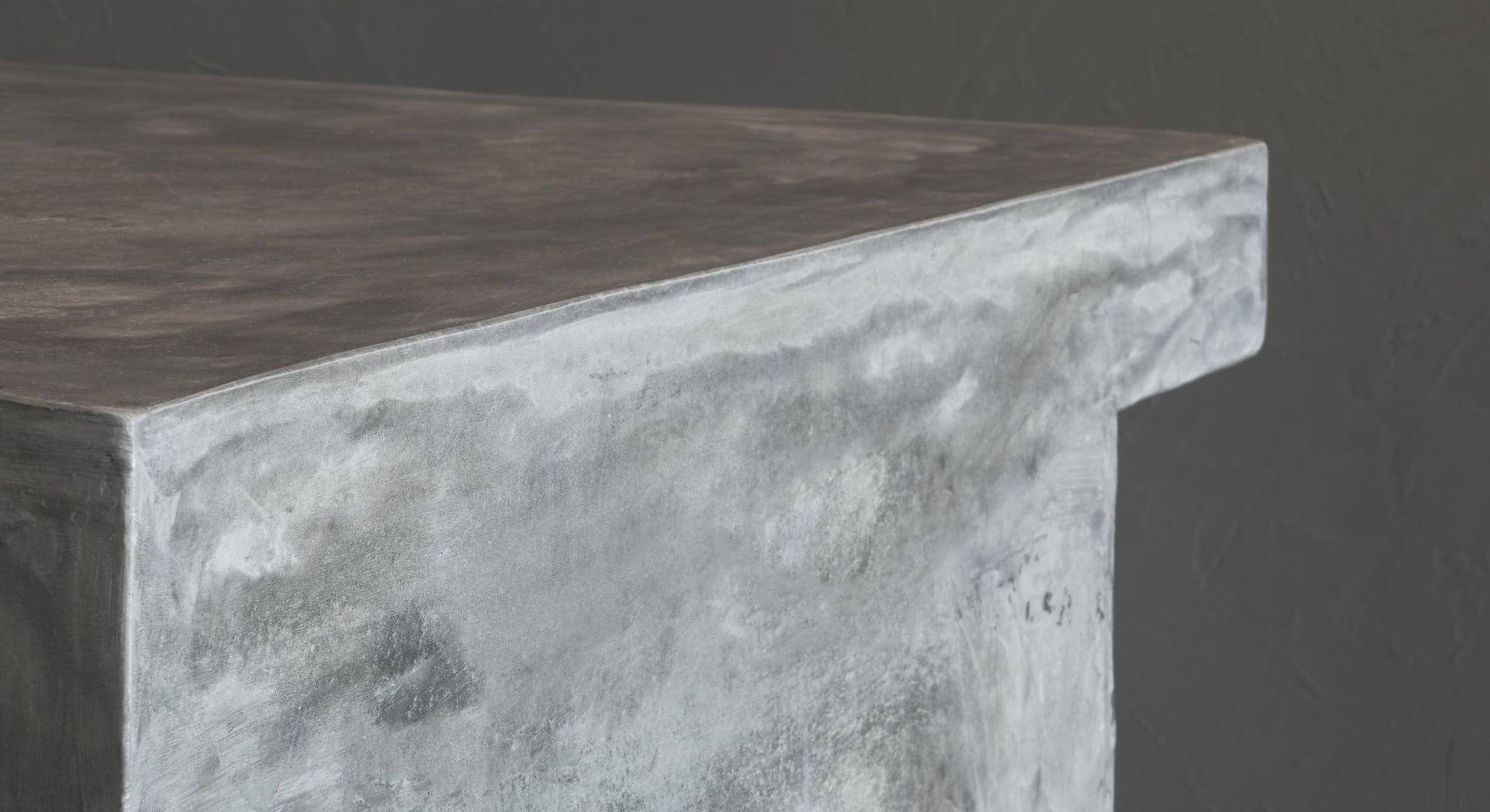 Close-up of a polished concrete countertop edge with natural grey tones