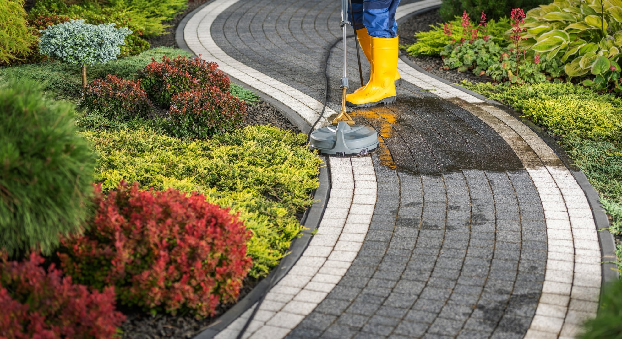 a person cleaning the concrete pathway