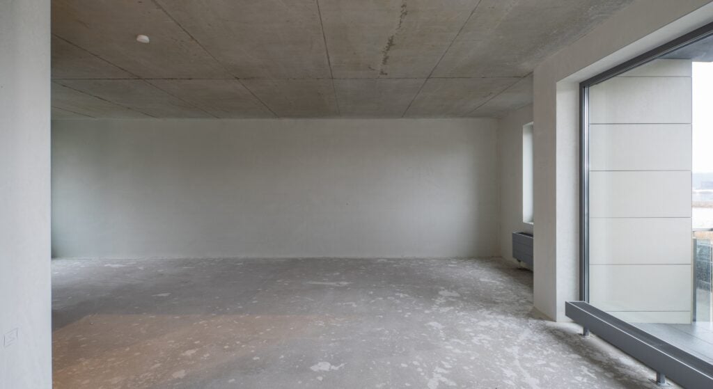 Empty unfinished room with concrete ceiling and large window