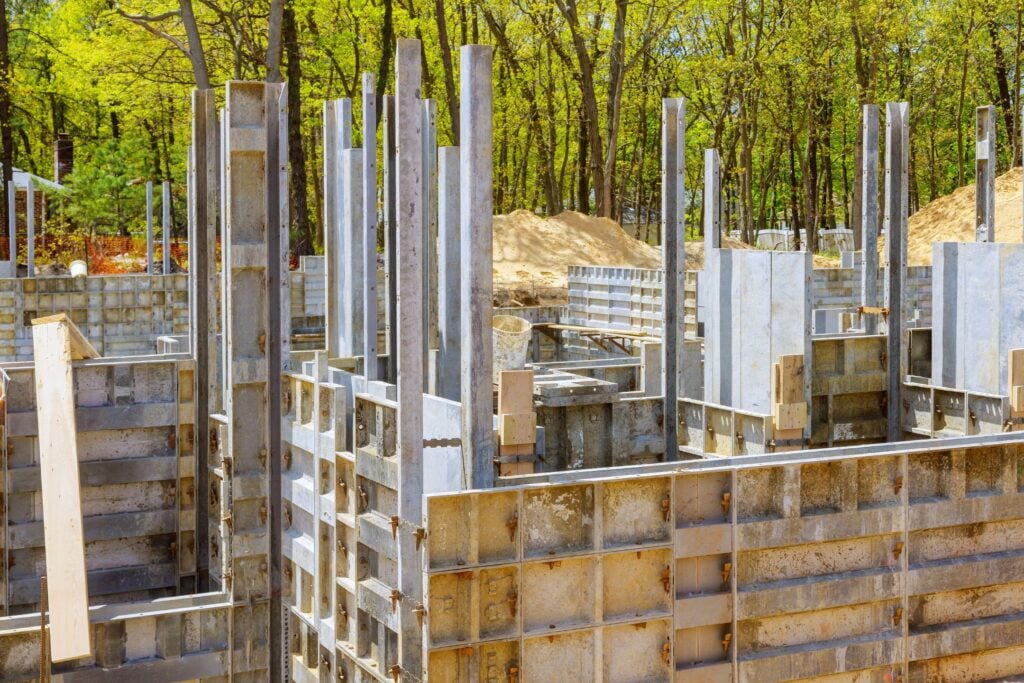 Concrete foundation formwork and steel columns at building site