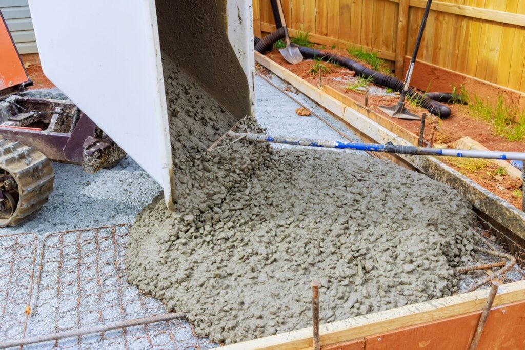Concrete being poured into slab formwork with reinforcement