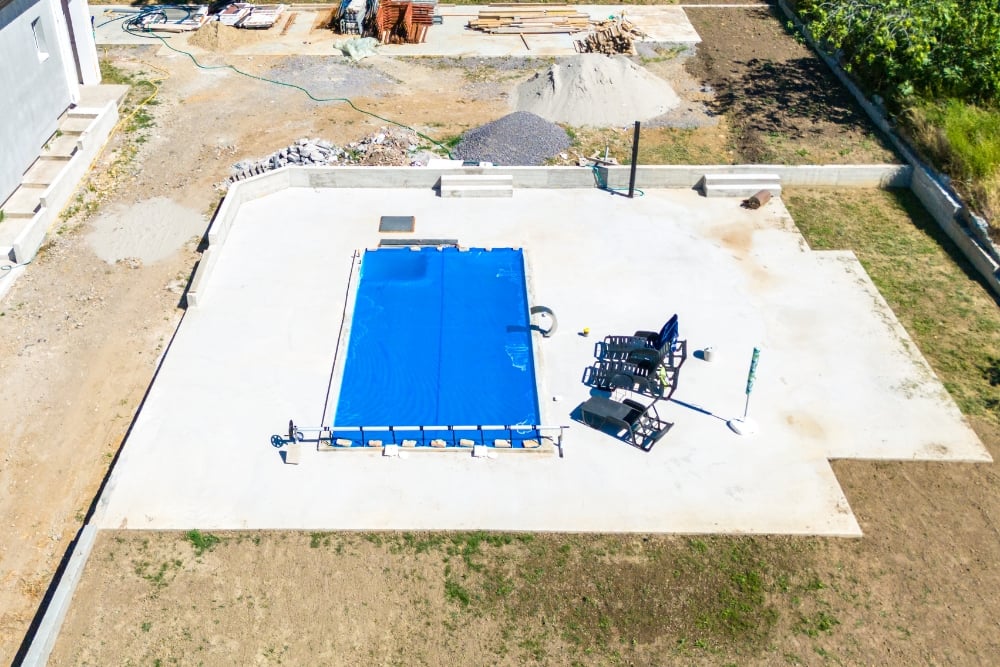 Aerial view of a newly installed honed concrete pool surround with a covered swimming pool.