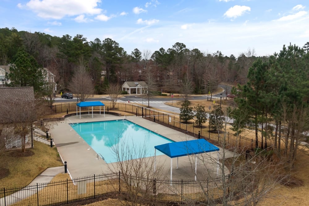 An outdoor rectangular swimming pool featuring a light grey concrete surround.