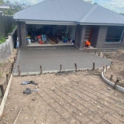 Fresh concrete driveway poured and levelled in front of residential garage