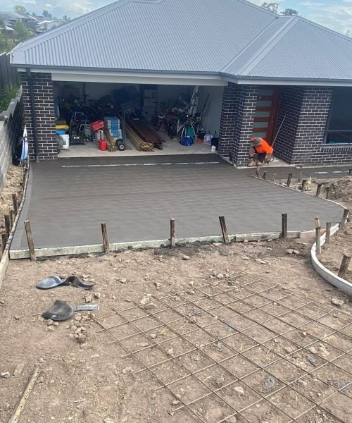 Fresh concrete driveway poured and levelled in front of residential garage