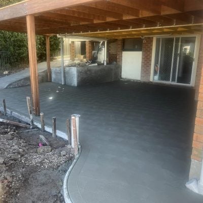 Freshly poured concrete patio beneath timber deck