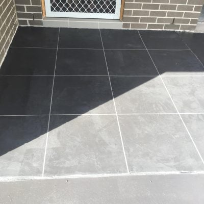 Dark grey tiled front porch with screen door
