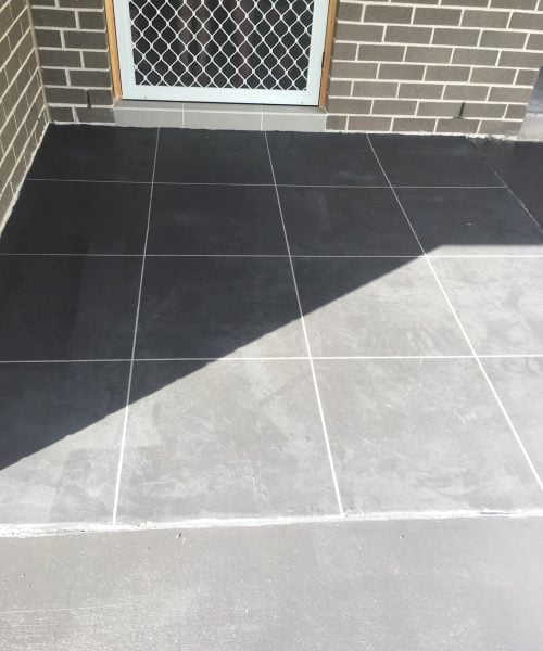Dark grey tiled front porch with screen door
