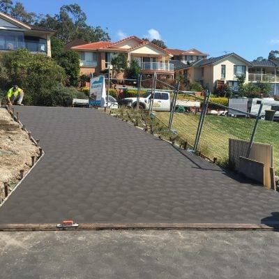 Freshly poured concrete driveway on suburban hillside property