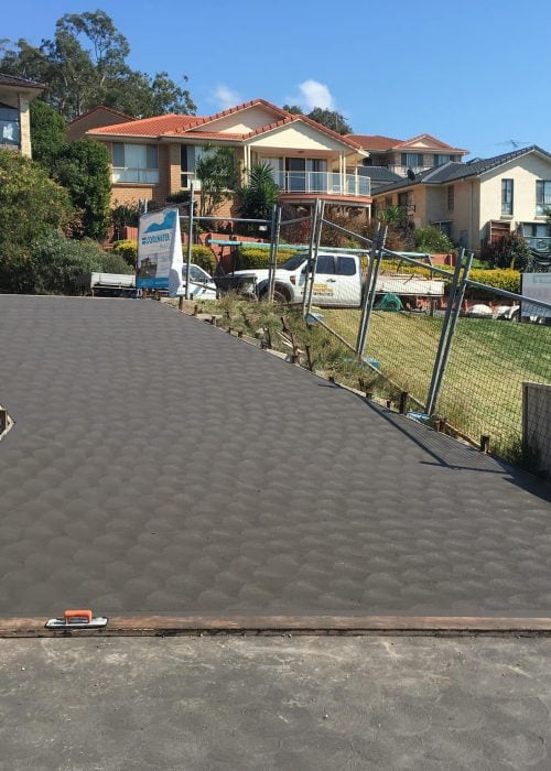 Freshly poured concrete driveway on suburban hillside property