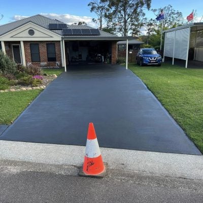 Fresh concrete driveway at suburban home with solar panels