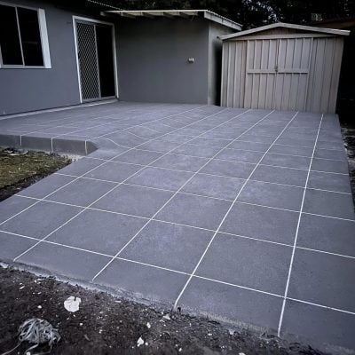 Newly tiled grey backyard patio with garden shed