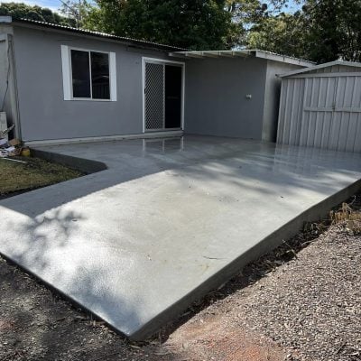 Grey backyard granny flat with concrete patio slab