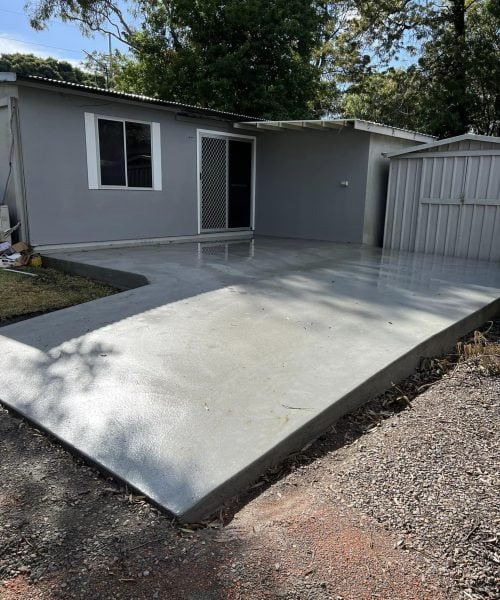 Grey backyard granny flat with concrete patio slab
