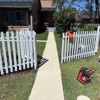 Brick house with white picket fence and solar panels