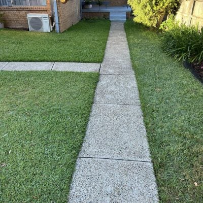 Concrete path through lawn to brick house porch
