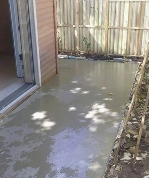 Fresh concrete driveway poured and levelled in front of residential garage