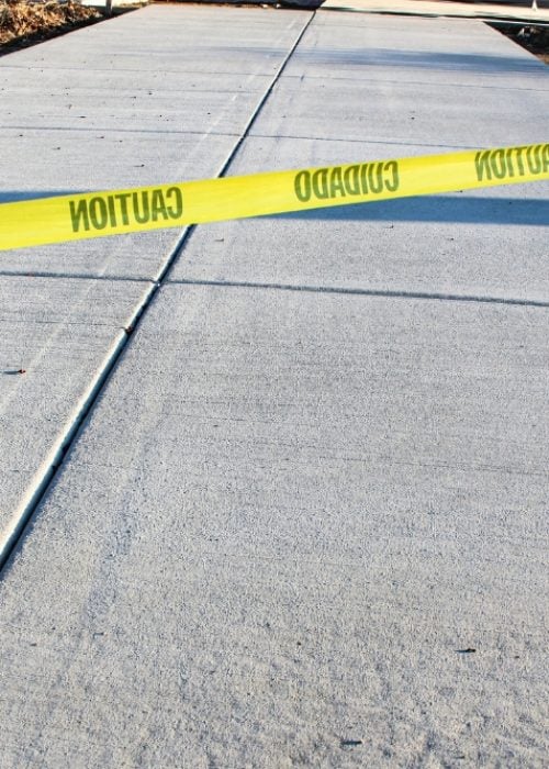A newly poured grey concrete driveway or sidewalk with control joints.