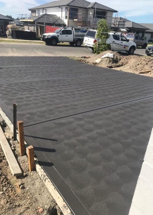 Freshly poured concrete driveway at suburban construction site
