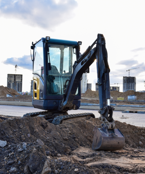 Mini excavator digging at urban construction site