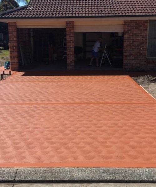 Newly paved red concrete driveway in suburban home