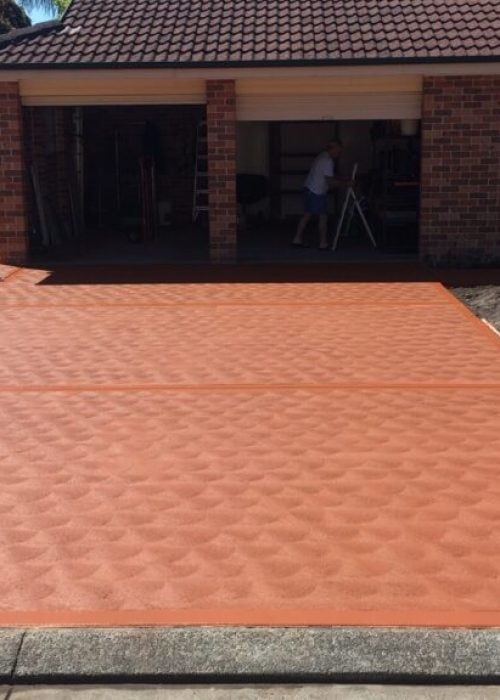 Newly paved red concrete driveway in suburban home